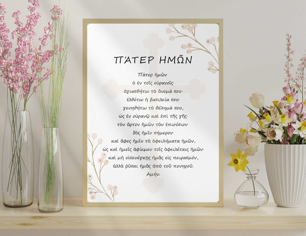 The Lord’s Prayer printable art in Greek with neutral floral design displayed on a wooden surface with vases of pink and yellow flowers